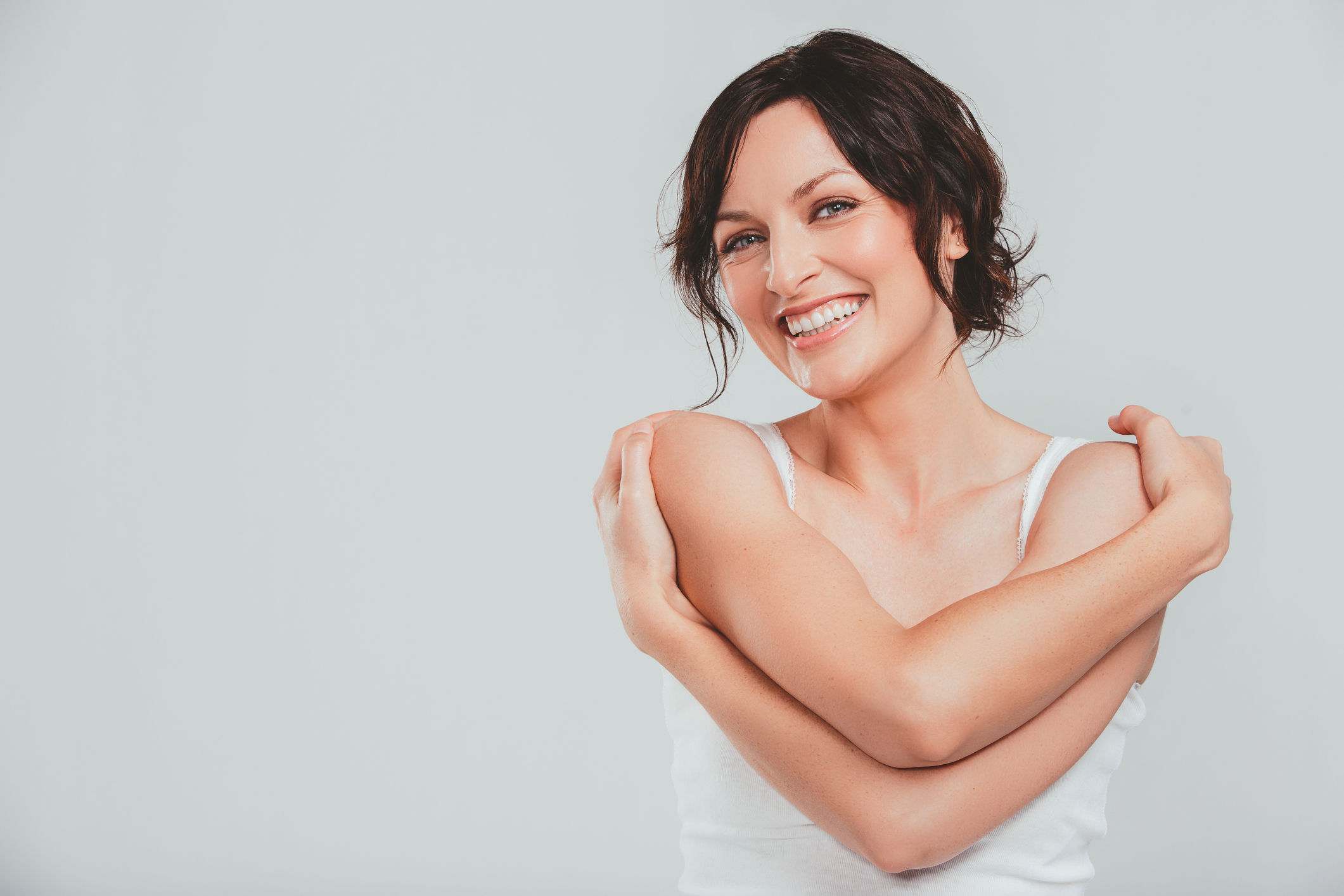 Woman hugging herself while smiling